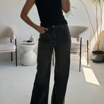 high-waisted black wide-leg jeans.