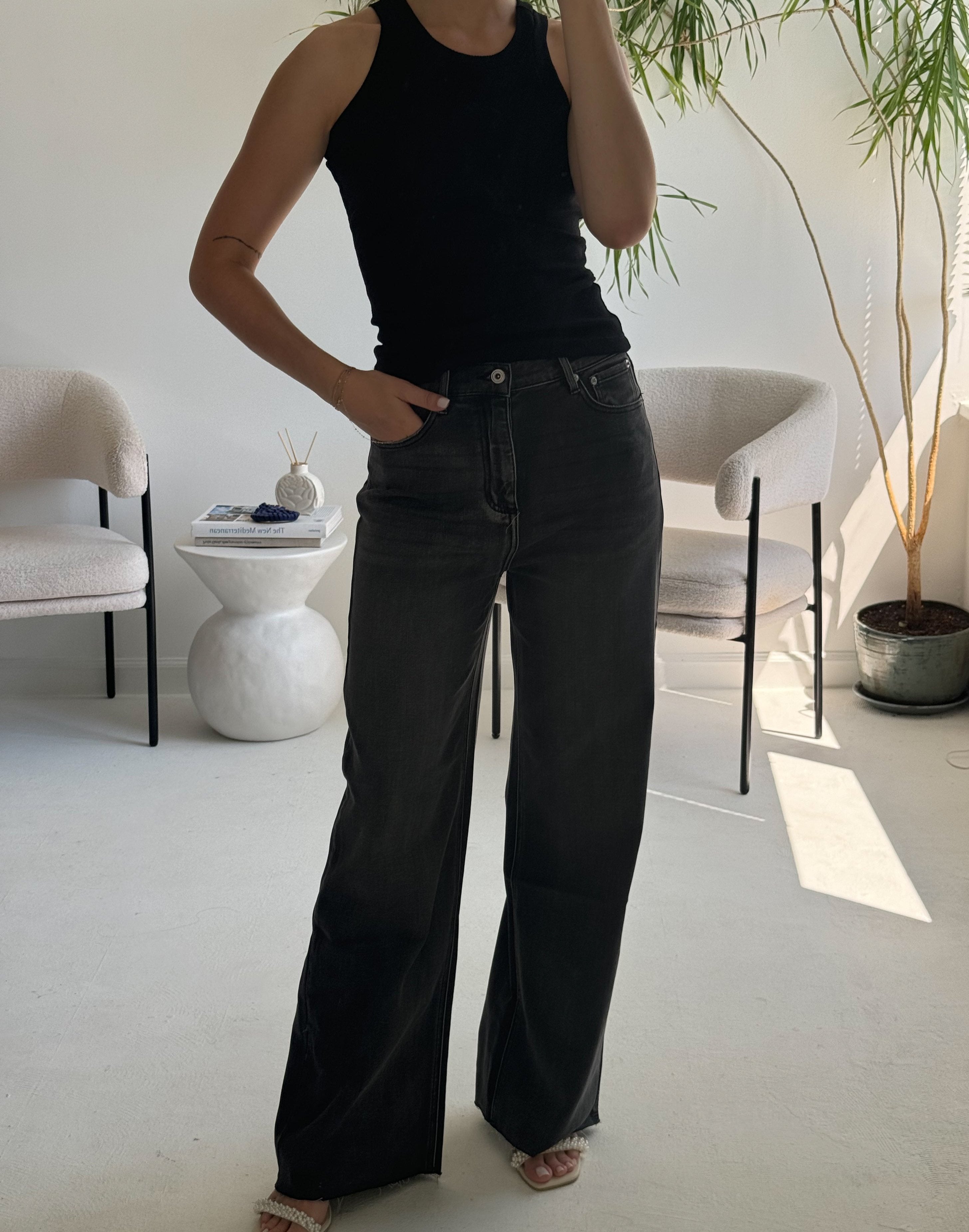 high-waisted black wide-leg jeans.