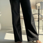 high-waisted black wide-leg jeans.