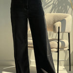 high-waisted black wide-leg jeans.